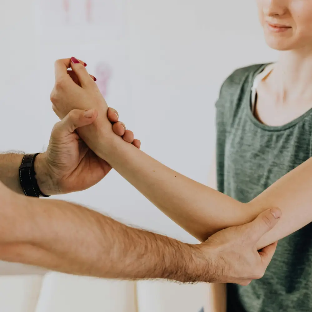 A physical therapist or doctor examines a patient's wrist and forearm, focusing on range of motion or injury assessment.
