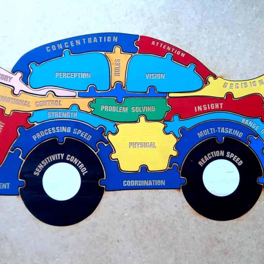 A colorful, car-shaped wooden puzzle with various cognitive, emotional, and physical skills written on its interlocking pieces.
